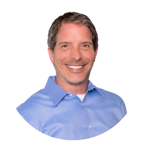 Untitled design (70) Smiling middle-aged man with short brown hair wearing a light blue collared shirt, photographed against a plain white background in a circular frame.
