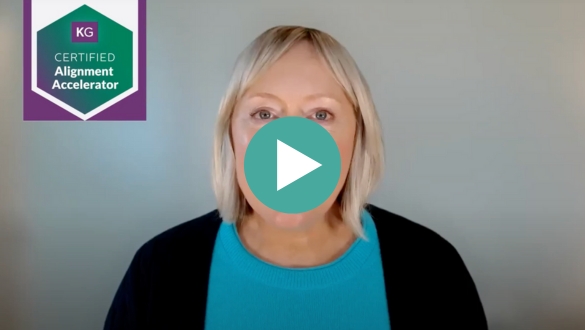 A woman with blonde hair wearing a turquoise top and dark sweater faces the camera. A "KG Certified Alignment Accelerator" badge appears in the top left corner. A play button overlay suggests this is a video thumbnail.